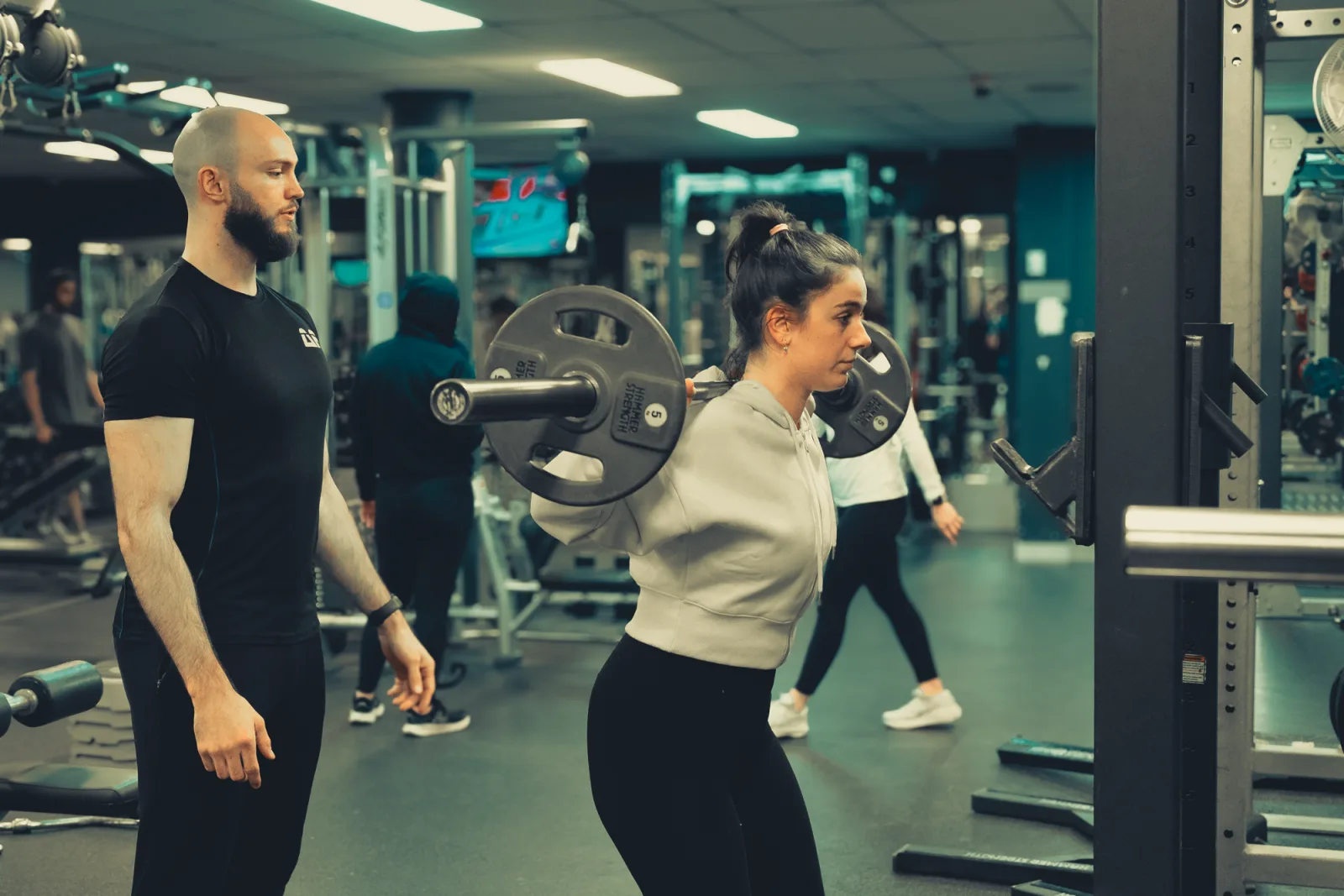 Edwin Henrich spotting a client through a barbell squat